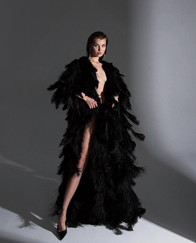 woman wearing dramatic black feather robe for luxury photoshoot