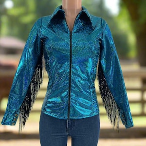 Puede incluir: Una chaqueta azul turquesa con flecos negros en las mangas y una cremallera negra. La chaqueta tiene un acabado brillante e iridiscente.