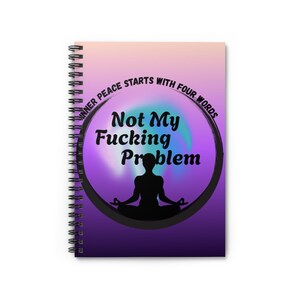 May include: Spiral-bound notebook with a colorful cover. The cover features the text "Inner peace starts with four words" and "Not My Fucking Problem" in a circular design. A silhouette of a person in a yoga pose is in the center.