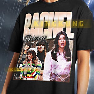 May include: Black unisex t-shirt featuring a graphic print of a group of women with the text "Rachel Berry" and "KINGKUNG" printed on the front.