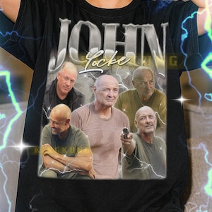 Könnte beinhalten: Schwarzes T-Shirt mit einer Grafik von John Locke aus der Fernsehserie "Lost". Das Design enthält mehrere Bilder der Figur und den Namen "John Locke" in einer stilisierten Schriftart. Das T-Shirt wird von einer Person getragen.