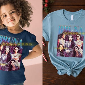 May include: A navy blue t-shirt featuring a graphic of six women with the text "BRUNA Magazine". The image has a vintage aesthetic with a purple and gold color scheme. The shirt is displayed on a child.