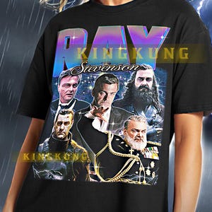 Pode incluir: Camiseta unisex preta com uma estampa gráfica de um grupo de homens de terno e um grande texto sobreposto que diz "RAY KINGKUNG Stevenson".