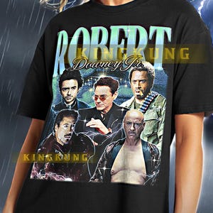Könnte beinhalten: Schwarzes T-Shirt mit einem Grafikdruck von Robert Downey Jr. in verschiedenen Rollen. Der Text "KINGKUNG" und "Downey Jr." ist auf dem T-Shirt aufgedruckt.