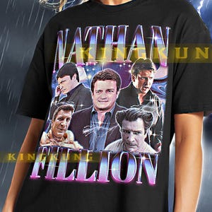 May include: Black unisex t-shirt featuring a graphic print of Nathan Fillion's face surrounded by other faces. The text "NATHAN FILLION" is printed in a purple and pink gradient.