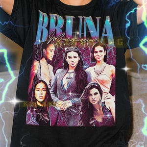 May include: Black t-shirt featuring a graphic of five women with the text "BRUINA" in a stylized font. The image has a vintage aesthetic with lightning bolt accents. A unisex shirt.