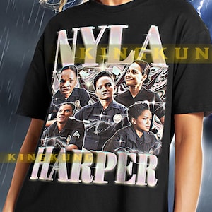 May include: Black t-shirt with a graphic print of a group of women wearing police uniforms. The text "NYLA HARPER" is printed on the shirt in a glittery font.
