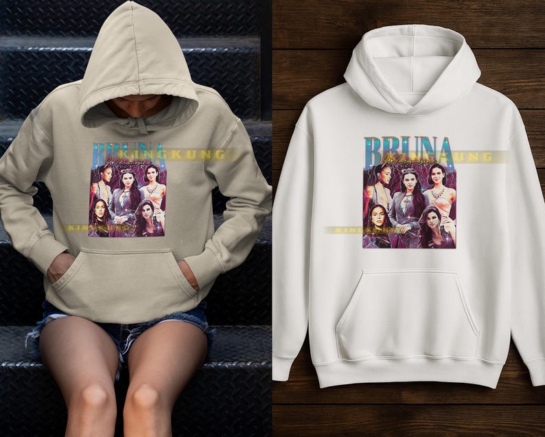 May include: Beige and white hooded sweatshirts. Each sweatshirt features a graphic of a group of women with the text "BRUNA KING KUNG" in a blue and gold font. The sweatshirts have a front pocket and a drawstring hood.