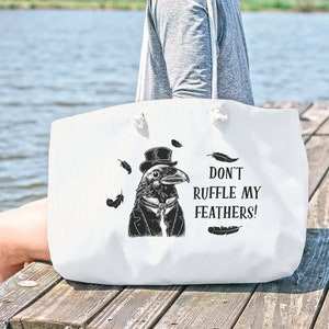 May include: White tote bag with a black and white illustration of a crow wearing a top hat and bow tie. The text on the bag reads "Don't ruffle my feathers!"