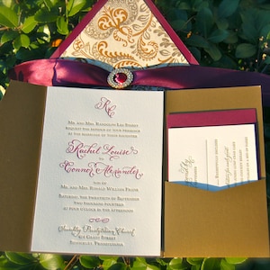 May include: A burgundy and gold wedding invitation with a decorative pattern on the front. The invitation is for the wedding of Rachel Louise to Connor Alexander on 20th September 2014 at 4:00 PM at Trinity Presbyterian Church in Sewickley, Pennsylvania.