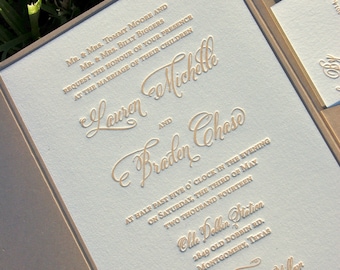 Puede incluir: Una invitación de boda azul claro con letras doradas. La invitación anuncia el matrimonio de Lauren Michelle y Braden Chase. La boda tendrá lugar a las cinco y media de la tarde del sábado 3 de mayo de 2014 en la estación de Olle Dollin, 2849 Old Dobbin Rd., Montgomery, Texas. La invitación también menciona una recepción para adultos que seguirá.