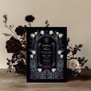 May include: Black wedding invitation with a floral design featuring white flowers, purple and green leaves, and a gold arch. The text reads "Josephine and Adrian" and "Aug 23 2025".