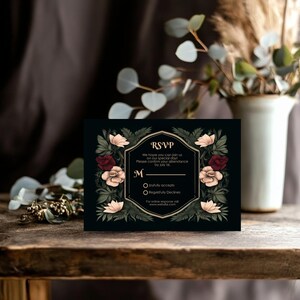 May include: Black RSVP card with gold accents and floral border. The text reads "RSVP" and includes a request to confirm attendance by July 1st. The card has two options for guests to choose from: "Joyfully accepts" or "Regretfully Declines".