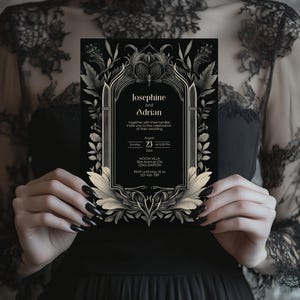 Könnte beinhalten: Schwarze und goldene Hochzeitseinladung mit einem gotischen Bogen-Design und floralen Akzenten. Die Einladung lautet "Josephine und Adrian" und enthält Datum, Uhrzeit und Ort der Hochzeit. RSVP-Informationen sind ebenfalls enthalten.