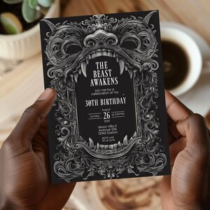 May include: A black and white invitation with an ornate, detailed design featuring a monstrous creature's face with sharp teeth. The text reads "The Beast Awakens" and invites guests to a 30th birthday celebration. The invitation includes the date, time, and location of the event.