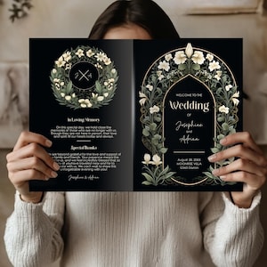 Op de afbeelding: Zwarte huwelijksuitnodiging met gouden accenten en bloemmotieven. De tekst luidt "Welkom op de bruiloft van Josephine en Adrian" en bevat de datum, locatie en het adres.