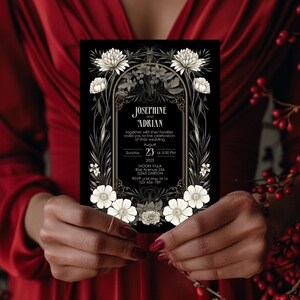 K&ouml;nnte beinhalten: Schwarze Hochzeitseinladung mit wei&szlig;en floralen Akzenten und goldenen Lettern. Die Einladung lautet "Josephine und Adrian zusammen mit ihren Familien laden Sie zur Feier ihrer Hochzeit am 23. August 2025 um 17:00 Uhr in der Moon Villa, Rise Avenue 234, 12345 Darton ein. RSVP bis zum 1. Mai an 123-456-789"