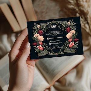 May include: A black RSVP card with gold accents and floral designs. The text reads "RSVP" and "We hope you can join us on our special day! Please confirm your attendance by July 1st. M joyfully accepts Regretfully Declines For online response visit www.website.com"