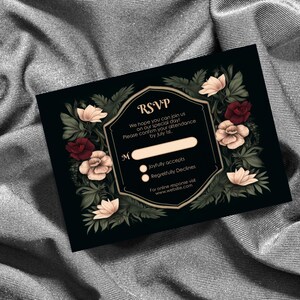 May include: Black RSVP card with gold trim and floral accents. The card has a section for a name and two options: Joyfully accepts and Regretfully Declines. The text reads: "RSVP We hope you can join us on our special day! Please confirm your attendance by July 1st. For online response visit www.website.com"
