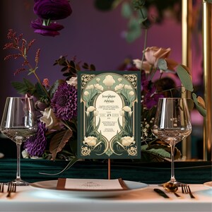 May include: A green and gold wedding invitation with an art deco design featuring white calla lilies. The invitation reads "Josephine & Adrian" and includes the date "23" and the location "MOONCREST VILLA & GARDENS CARTON".