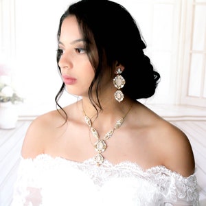 Antique gold statement earrings and matching necklace with Swarovski Crystals on model