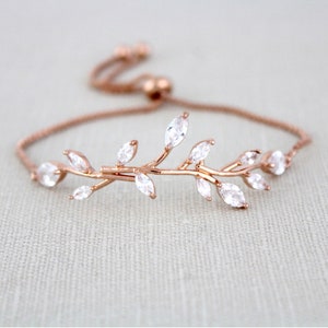 May include: A delicate rose gold bracelet with a delicate branch design adorned with sparkling clear cubic zirconia stones. The bracelet features an adjustable sliding clasp for a perfect fit.