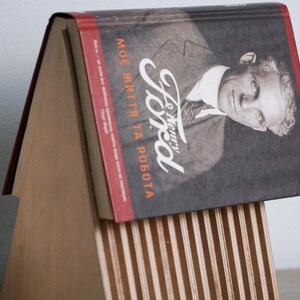 May include: A wooden book stand with a red and black book titled "Henry Ford, My Life and Work".