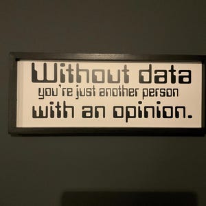 May include: A black framed sign with white background and black text that reads "Without data you're just another person with an opinion."