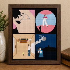 May include: A framed cross-stitch artwork featuring four distinct pixelated scenes. The top left shows a profile, the top right a figure in a pink circle, the bottom left an interior room with a person, and the bottom right a person under a night sky.