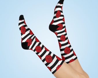 Könnte beinhalten: Ein Paar schwarz-weiß gestreifte Socken mit roten Rosenmustern. Die Socken sind kniehoch und werden an den Beinen einer Person getragen.