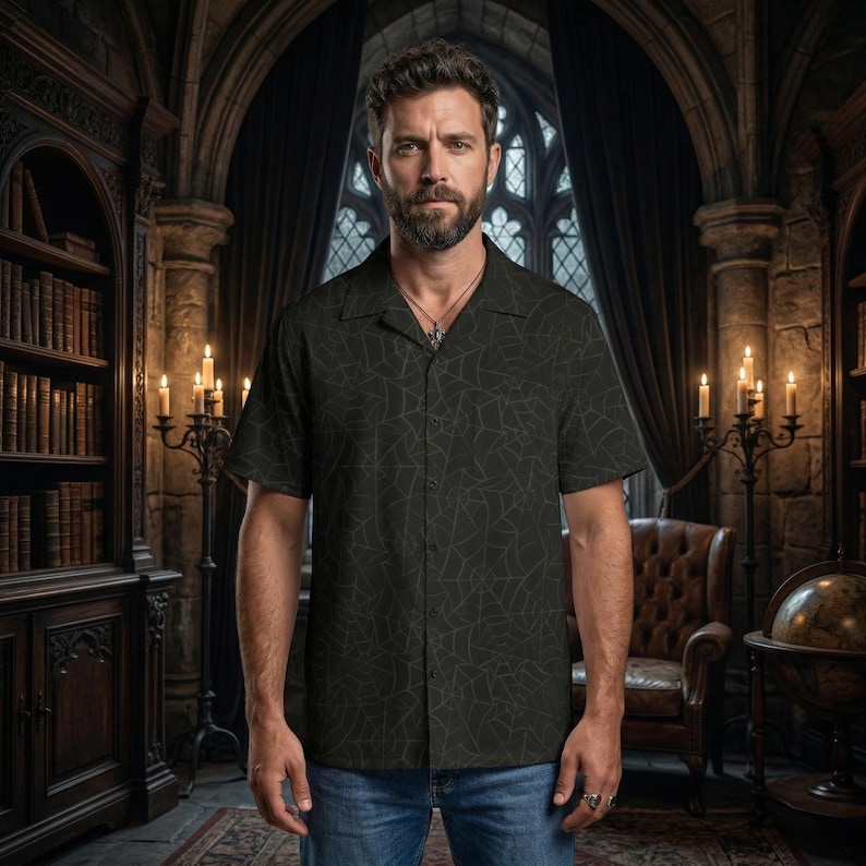 K&ouml;nnte beinhalten: Ein dunkelgr&uuml;nes kurz&auml;rmeliges Hemd mit Spinnennetz-Muster. Das Hemd hat einen Camp-Kragen und wird mit einer blauen Jeans getragen. Der Hintergrund zeigt eine Bibliothek mit B&uuml;cherregalen, Kerzen und einem Ledersessel.