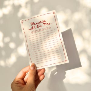 May include: A white card with a red border and the text "Memories with the Mrs."  Write down a memory you have with the bride-to-be. The card will be read out loud and if the groom guesses it, you win!