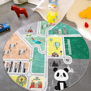 May include: A round, gray and green play mat with a city street design. The mat features a panda, a fire truck, a car, a tent, a ferris wheel, and a park. The mat is perfect for children to play on and learn about different places.