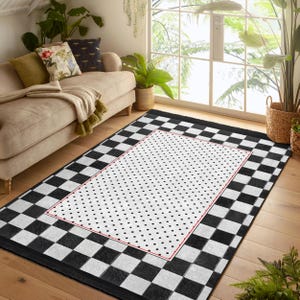 Puede incluir: Alfombra a cuadros negros y blancos con una sección central blanca adornada con un patrón de lunares negros. La sección central está bordeada de rojo.