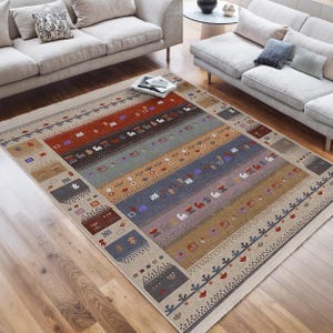 May include: A multi-coloured patterned rug with a cream background. The rug features a variety of geometric shapes and designs in shades of red, orange, yellow, blue, green, and brown.