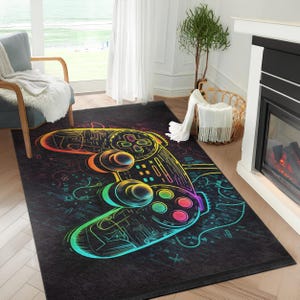 Peut inclure: Tapis rectangulaire noir avec une illustration colorée d'une manette de jeu vidéo. Le design de la manette utilise un spectre de couleurs, notamment le jaune, l'orange, le vert et le violet. Idéal pour un salon ou une salle de jeux.