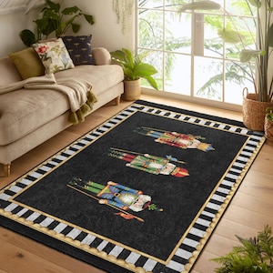 Puede incluir: Una alfombra de rayas blancas y negras con un borde dorado presenta un diseño de tres soldados cascanueces con trajes coloridos. La alfombra tiene un fondo negro con un borde de rayas blancas y negras.