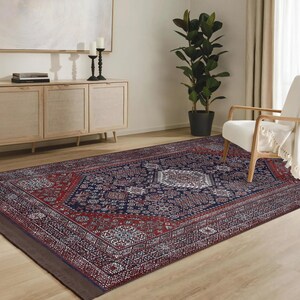 May include: A navy blue, red, and white patterned rug with a traditional design. The rug is laid out on a hardwood floor in a living room setting.