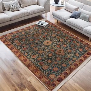 Könnte beinhalten: Ein Teppich im Vintage-Stil mit einem floralen Muster in Rot-, Orange-, Blau- und Grüntönen. Der Teppich hat einen weißen Rand und liegt auf einem Holzboden.