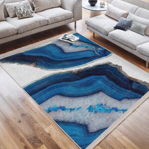 Può includere: Tappeto da area astratto blu e bianco con un design geometrico di agata. Il tappeto ha uno sfondo bianco con motivi di agata blu e bianchi.