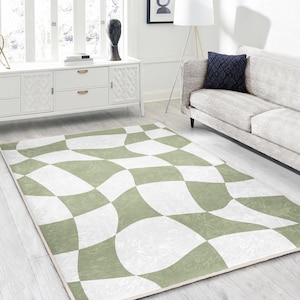 Può includere: Un tappeto geometrico verde e bianco con un design ondulato. Il tappeto è su un pavimento in legno chiaro in un soggiorno.