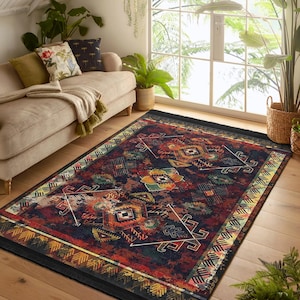 May include: A colourful rug with a geometric pattern in shades of red, orange, yellow, green, and blue. The rug has a black background and a fringe border.