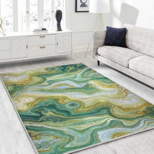 Può includere: Tappeto da area astratto con un motivo marmoreo verde, oro e bianco. Il tappeto ha un design moderno e contemporaneo.