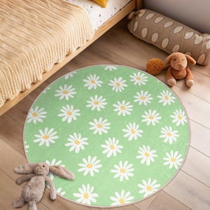 May include: A green round rug with a white daisy pattern. The rug is perfect for a playroom or nursery.