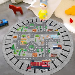 May include: A round gray play mat with a road and town design. The mat features a train, buildings, trees, and animal illustrations. The mat is designed for children's play and is suitable for a playroom or bedroom.