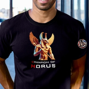 May include: Black t-shirt with a gold image of the Egyptian god Horus with wings and a staff. The text "Champion of Horus" is printed below the image.