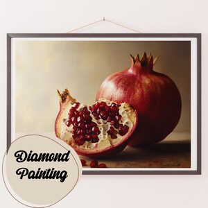Op de afbeelding: Een close-up van een rode granaatappel, opengeknipt om de sappige rode zaden erin te laten zien. De granaatappel ligt op een houten oppervlak, met een paar zaden eromheen verspreid.  Diamond Painting.