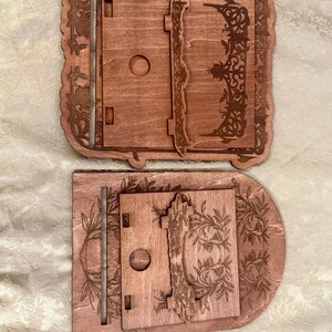 Puede incluir: Dos estantes de madera con intrincados dise&ntilde;os cortados con l&aacute;ser. Los estantes son de madera marr&oacute;n claro y tienen un patr&oacute;n floral. Los estantes est&aacute;n apilados uno encima del otro.