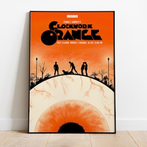 May include: A framed poster with an orange and black color scheme. The poster features the title "Clockwork Orange" in bold black letters, with the text "Stanley Kubrick's" above it. The bottom of the poster has the text "Cult Classic Movies | Tuesday, 12-29 | 9:30 PM".