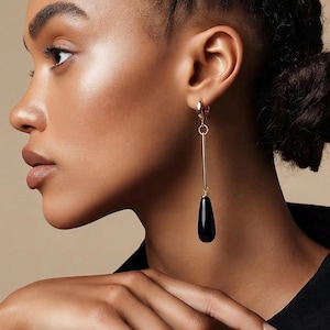 Black onyx drops on a long gold bar earrings. Hoop latch back closure.